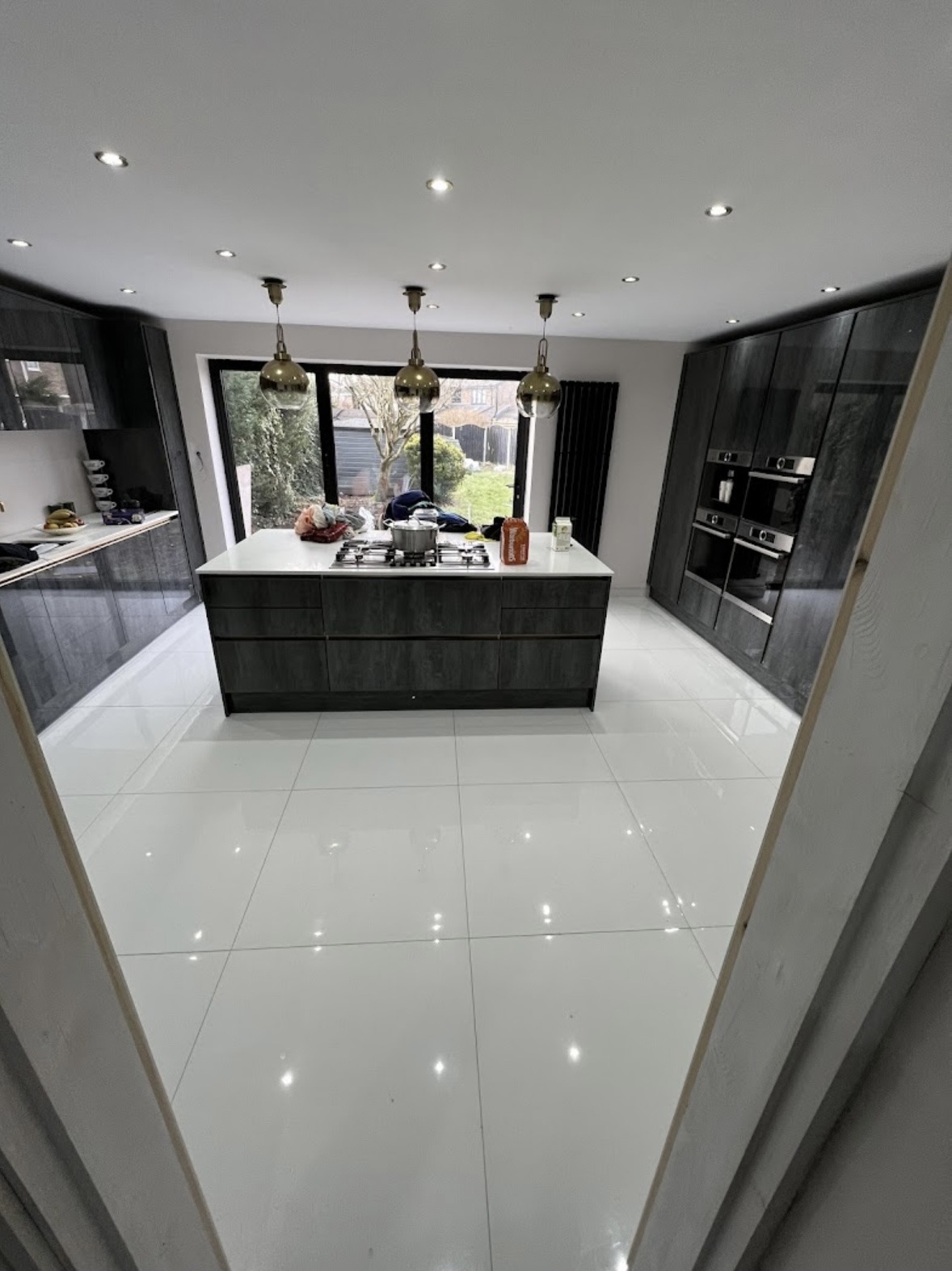 White gloss large-format tiled kitchen floor with dark units