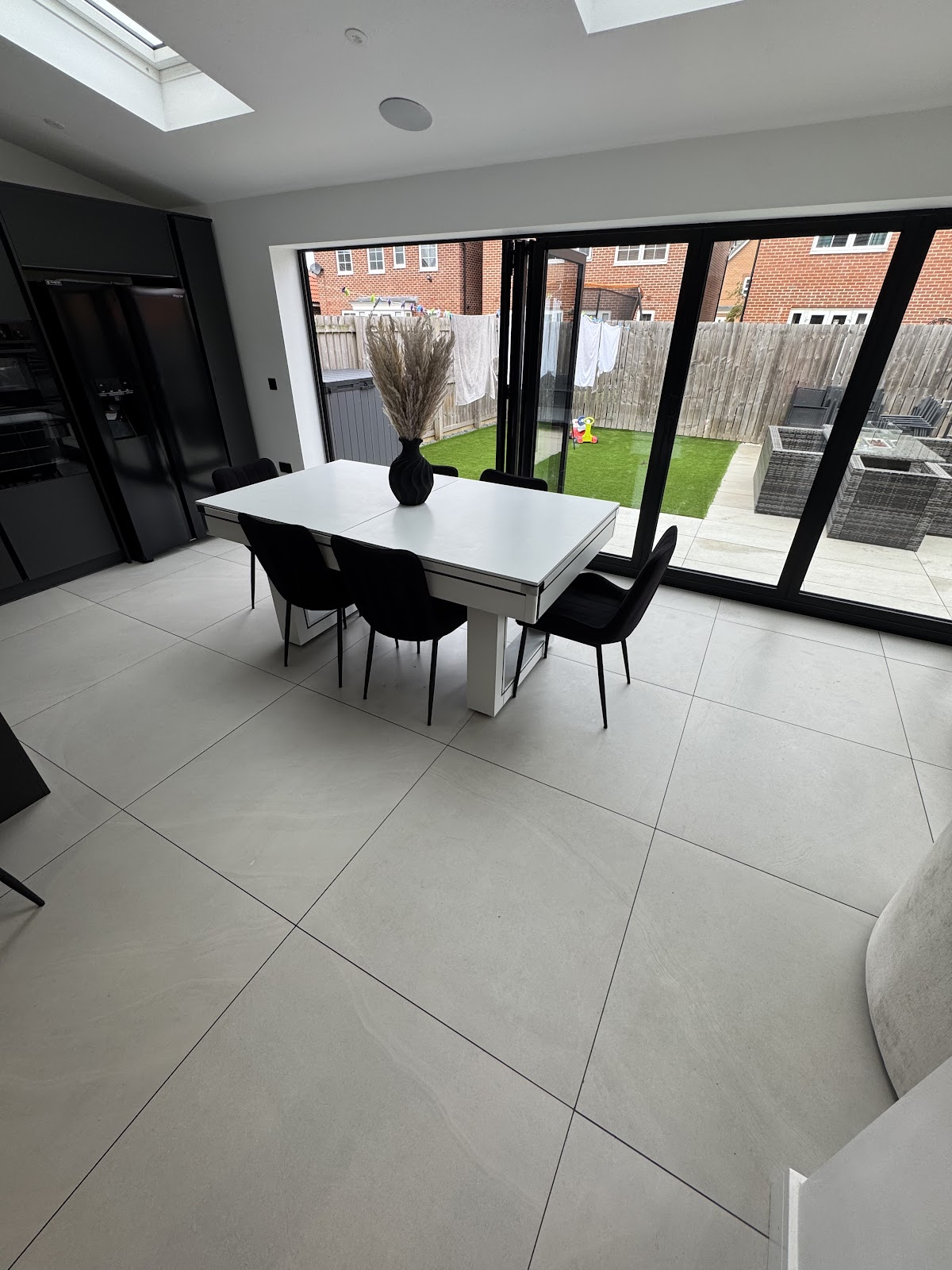 Large-format grey porcelain floor in an open-plan kitchen and dining extension